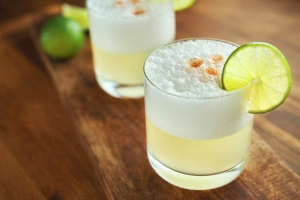 Cóctel pisco sour clásico servido en vaso con espuma blanca